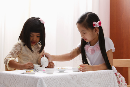 two little girls having a tea partyの写真素材