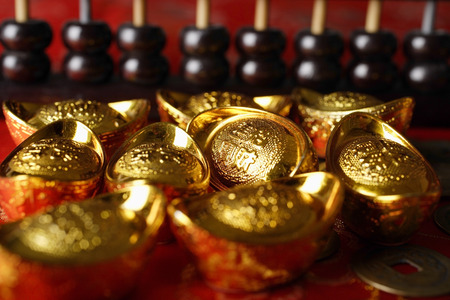 Close up of Chinese gold ingots and abacus.の写真素材