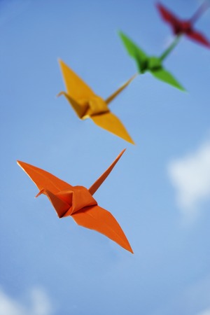 multiple paper cranes against sky backdropの写真素材