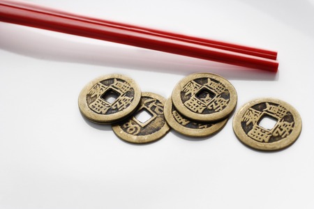 Chinese coins with red chopsticksの写真素材