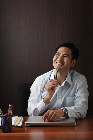 Man sitting at desk smilingの写真素材