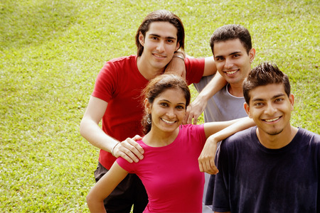 Young adults standing together, looking at camera, smilingの写真素材