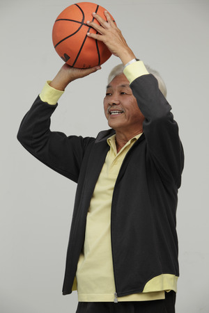 Mature Chinese man playing basketballの写真素材