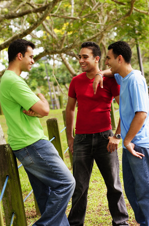 Young men standing, talkingの写真素材