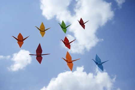 multiple paper cranes against sky backdropの写真素材