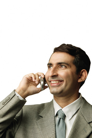 Businessman using mobile phone, looking awayの写真素材