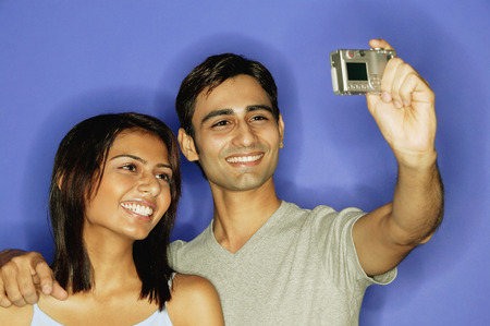 Couple taking a picture of themselves, smilingの写真素材