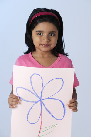 Little girl holding picture of flowerの写真素材