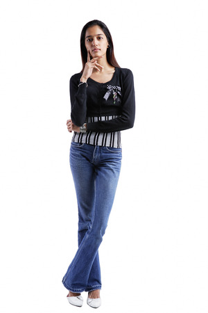 Woman standing, looking at camera, hand on chinの写真素材