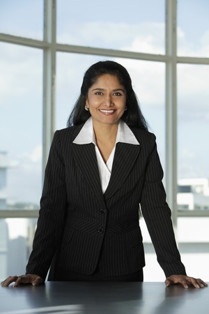 Indian woman standing at her desk