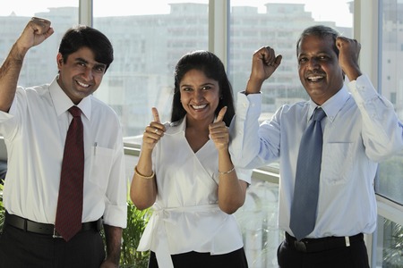 Three Indian people smiling making hand gestures
