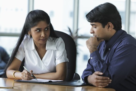Indian woman and man discussing workの写真素材