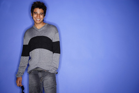 Man standing against blue background, smilingの写真素材