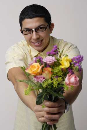 Young man holding bouquet of flowersの写真素材
