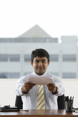 business man handing over a stack of paperの写真素材