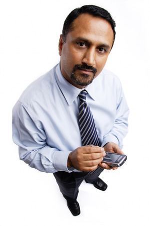 Businessman using PDA, looking at cameraの写真素材