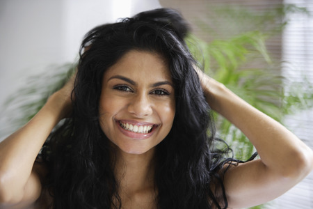Indian woman smiling and playing with her hairの写真素材