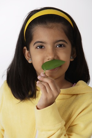 Girl smelling green leafの写真素材
