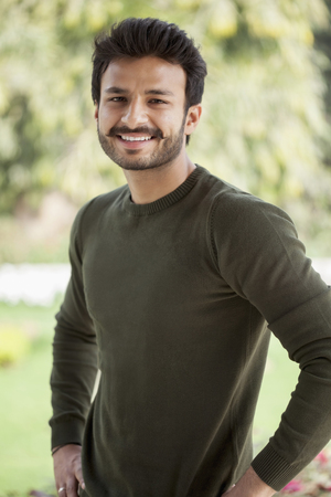 India, Smiley man standing with hands on hipsの写真素材