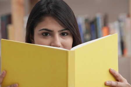 Woman with yellow bookの写真素材