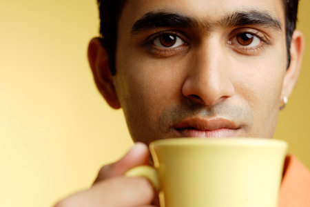 Man holding mug to mouthの写真素材