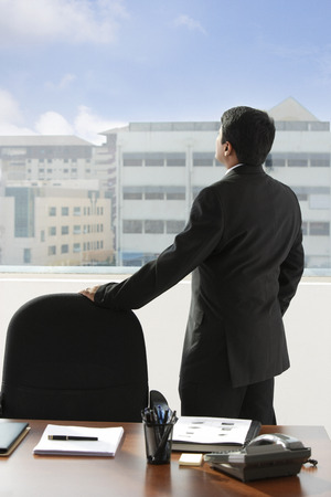 business man looking out of the windowの写真素材