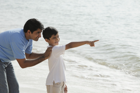 Father and son looking at the ocean.の写真素材