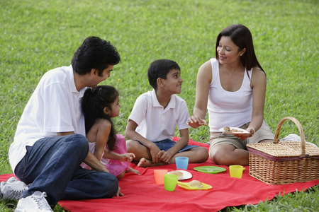 A family have a picnic together in the parkの写真素材
