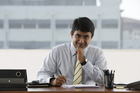 business man writing at his deskの写真素材