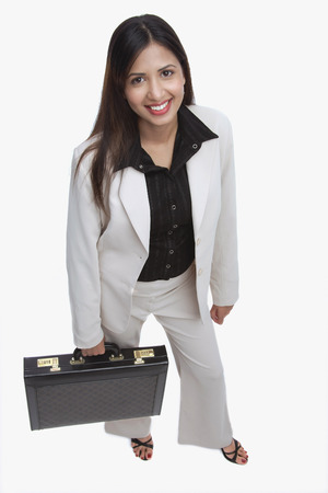 Businesswoman looking at camera, carrying briefcaseの写真素材