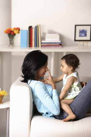 woman sitting at the couch with babyの写真素材