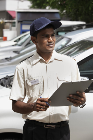 Security guard writing on clipboardの写真素材