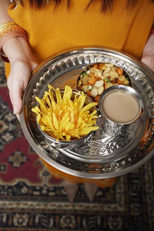 tight shot of a woman holding a tray of tea and snacksの写真素材