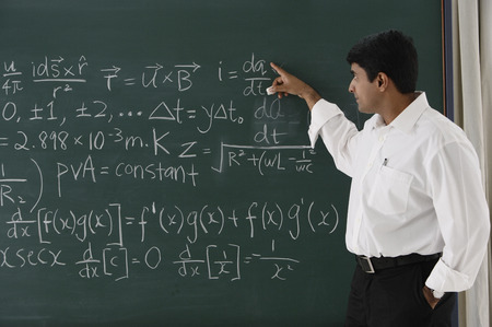 teacher explaining formula at chalkboard