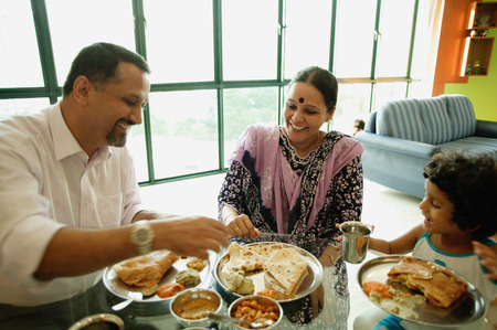 Family of three having a meal at homeの写真素材