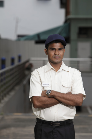 Security guard standing with arms folded