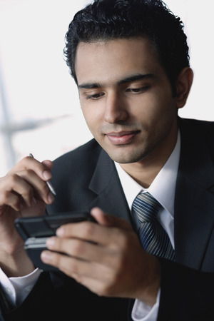 Young businessman using mobile phone, text messagingの写真素材
