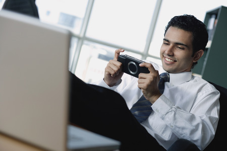 Young businessman playing Portable gameの写真素材