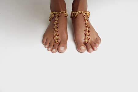 Woman's feet with anklet against white floorの写真素材