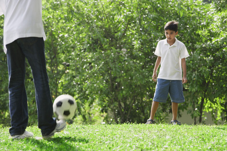A father and son play soccer togetherの写真素材