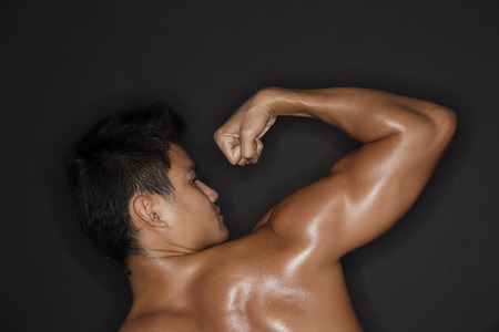 muscular man flexing armの写真素材