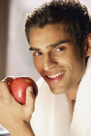 Man smiling with red appleの写真素材