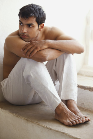 shirtless man resting chin on armの写真素材