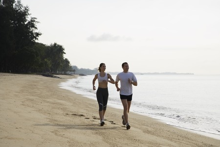 couple running on beachの写真素材
