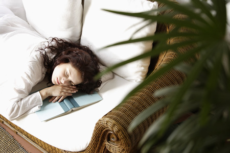 Woman asleep, head on bookの写真素材