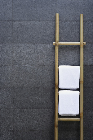 Ladder of towels leaning against slate wallの写真素材
