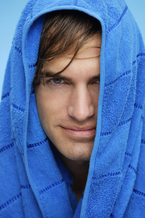 portrait of young man with blue towel on headの写真素材