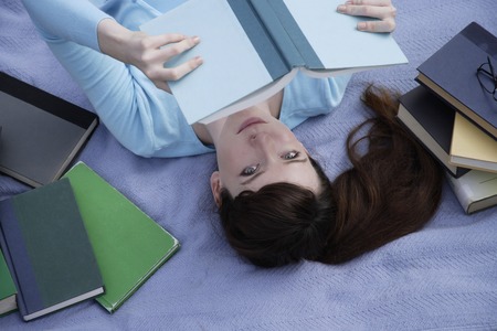 young woman surrounded by booksの写真素材