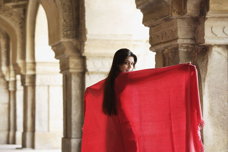 Woman in red shawl, standing in ancient monumentの写真素材