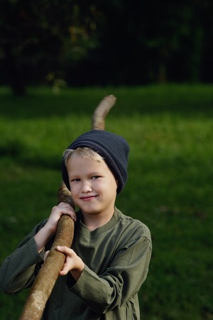 young boy holding big stickの写真素材